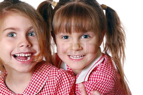 Porträt Von Zwei Glücklich Lächelnd Mädchen Gegen Weiß Stock Bild