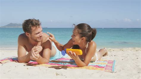 beach couple sun tanning putting stock footage video 100
