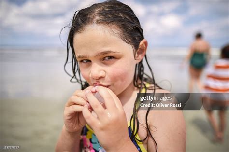 Portrait Of Girl With Wet Hair Licking Ice Cube On The Beach High Res