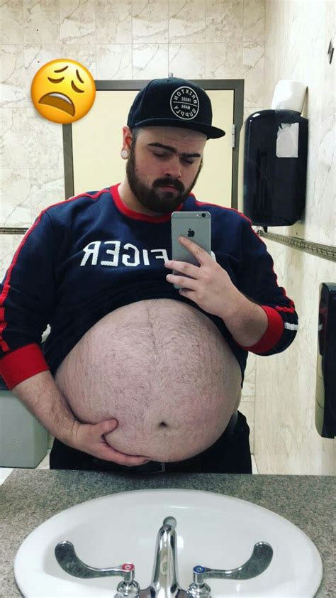 man holding  stomach  front   bathroom mirror