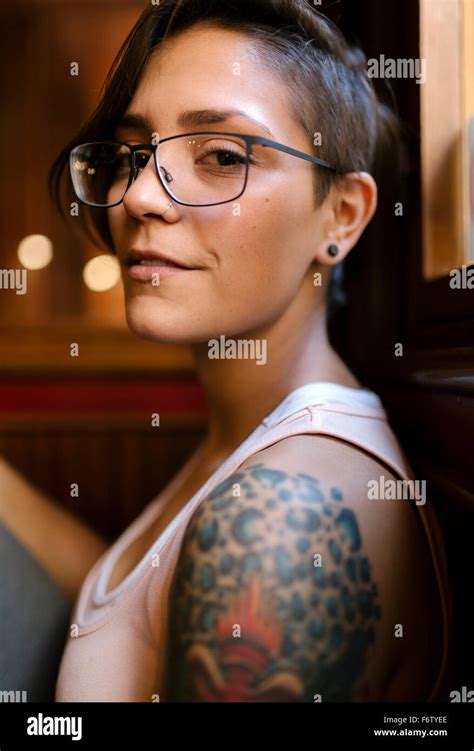 portrait  tattooed young woman  nose piercing wearing glasses