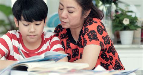 serious asian mother with son doing homework stock footage sbv