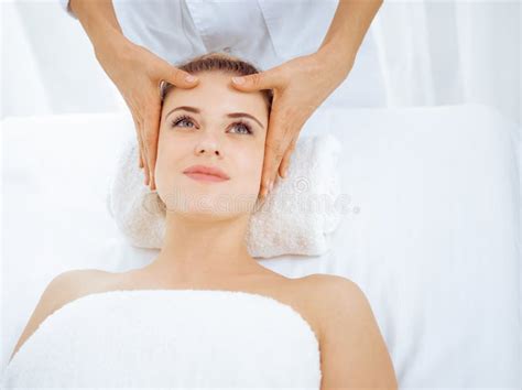 Young And Blonde Woman Enjoying Facial Massage In Spa Salon Beauty