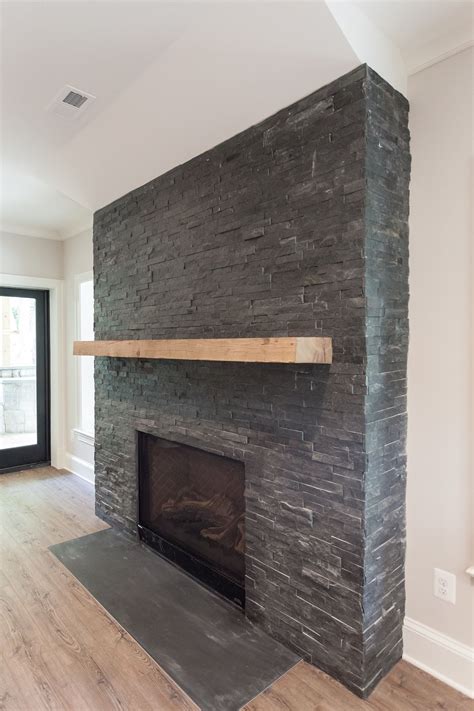black stacked stone fireplace  reclaimed natural wood mantel  walk  basement