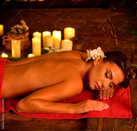 Massage Of Woman In Spa Salon Girl On Candles Background In Therapy