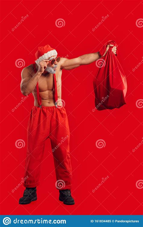 Adult Nude Santa Claus Looking At Sack Full Of Presents Stock Image