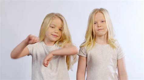 waist up shot of 6 year old caucasian twin sisters with long blonde