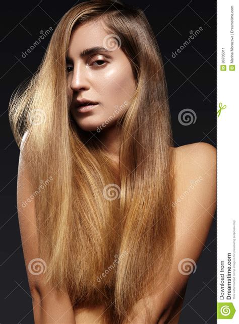 mujer joven hermosa con el pelo brillante largo peinado