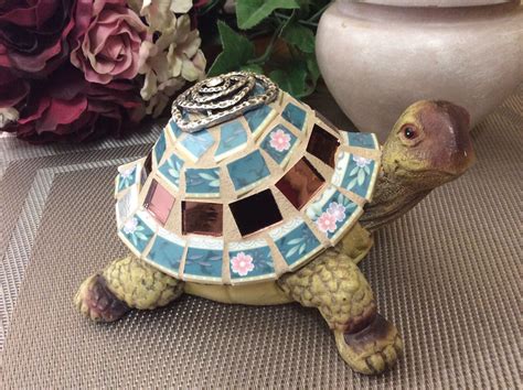 small turtle figurine sitting  top   table    flowers
