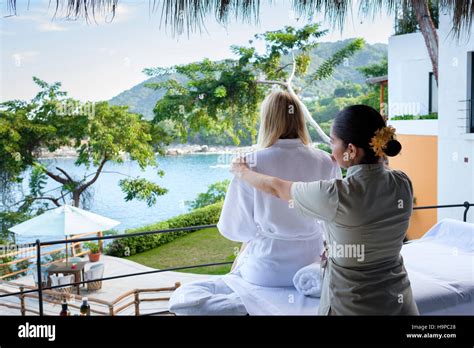 massage therapist helping woman to undress at luxury wellness retreat