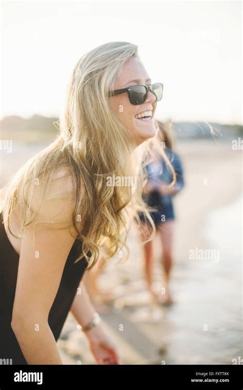Side View Of Blonde Woman On Beach Wearing Sunglasses Looking Away