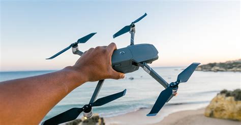 person holding gray  black quadcopter drone  stock photo