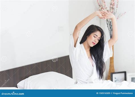 Asian Woman Stretching In Bed With Her Arms Raised Stock Image Image