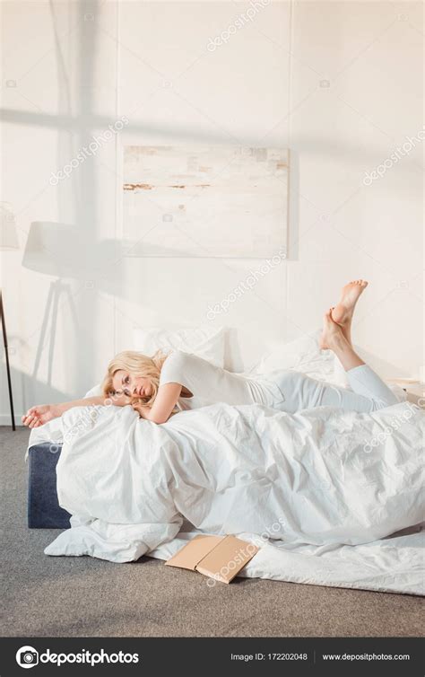woman relaxing  bed  morning stock photo  arturverkhovetskiy