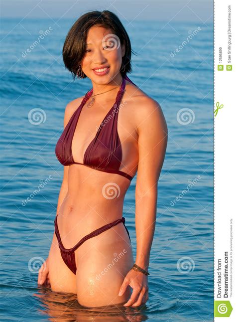 aantrekkelijke glimlachende aziatische vrouw in bikini stock afbeelding