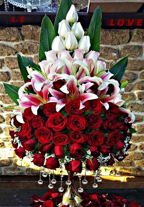 red roses  white lilies   vase   table    brick wall