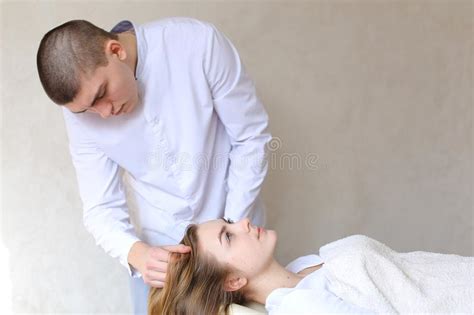 handsome guy massage therapist doing head massage for girl clien stock