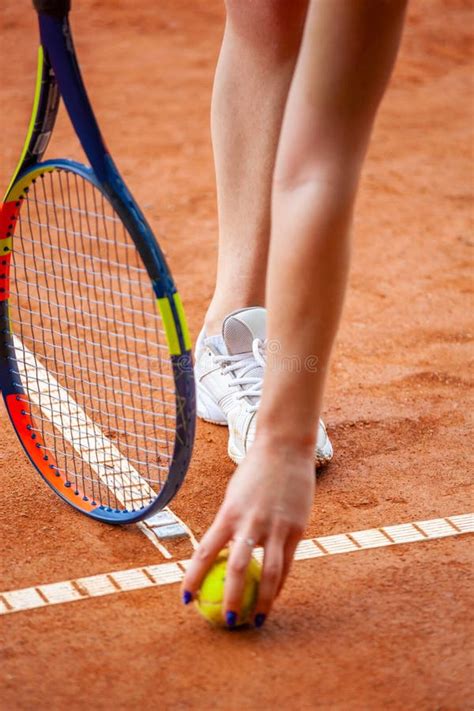 Female Tennis Player Legs In Tennis Shoes Standing On A Clay Court