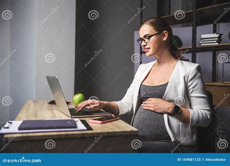 Young Pregnant Business Woman Using A Laptop In The Office Stock Image