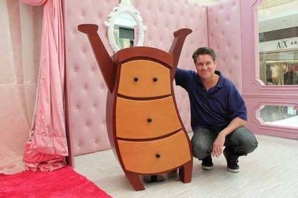man kneeling     giant bed   room  pink walls  furniture