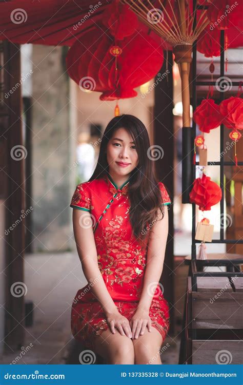 cute smiling asian chinese woman wearing cheongsam traditional red