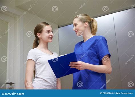 Glimlachende Verpleegster Met Klembord En Meisje Bij Het Ziekenhuis