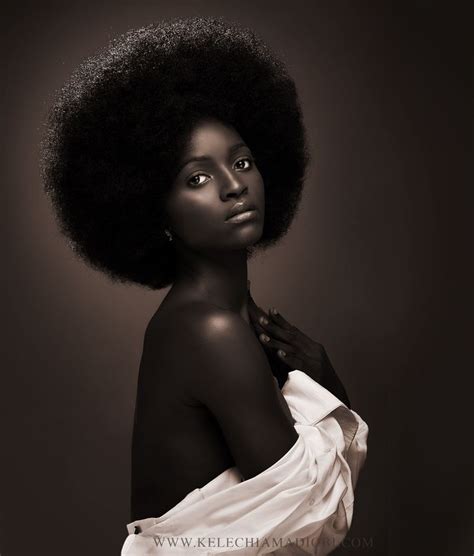 A Woman With An Afro Standing In Front Of A Dark Background