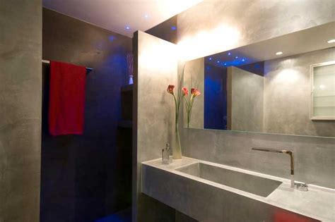 Applicazione di microcemento nel bagno sulla cima di vecchie ceramiche. Pavimento in microcemento spatolato Immagini
