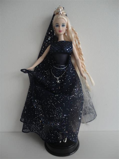 a barbie doll wearing a black dress and tiara with stars on it s head