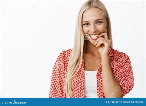 Portrait Of Flirty Feminine Blond Woman Biting Finger And Gazing