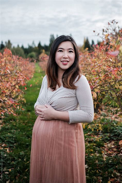 Portrait Of Pregnant Asian Woman Outdoor In A Park By Stocksy