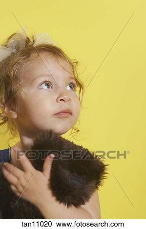 toddler girl holding stuffed animal stock image tan fotosearch