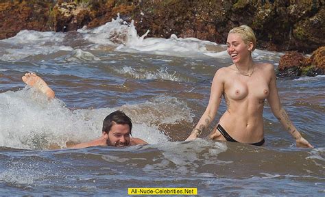 miley cyrus caught topless on a beach