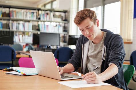 male student working  laptop  college library stock photo dissolve