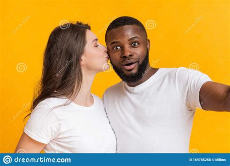 Joven Pareja Interracial Enamorada Tomando Selfie Mujer Besando A Su