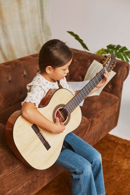 junges mädchen lernt wie man zu hause gitarre spielt kostenlose foto