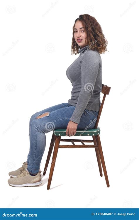 portrait of a woman sitting on a chair in white background looking at
