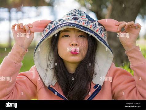 Sweet Asian Woman In Hoodie Making Faces Lifestyle Portrait Of Young