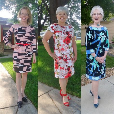 Three Women In Dresses Are Standing On The Sidewalk And One Woman Is
