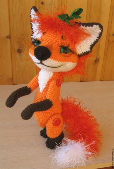 A Knitted Stuffed Fox Sitting On Top Of A Wooden Table