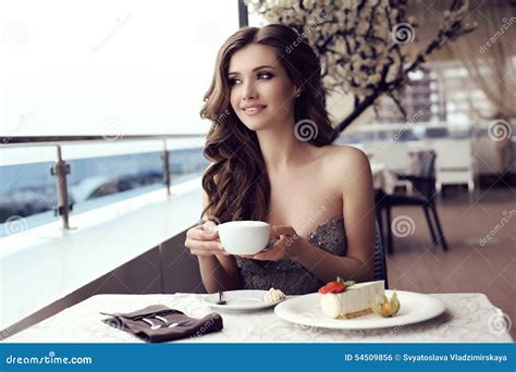 café de consumición de la mujer sensual en café al aire libre del