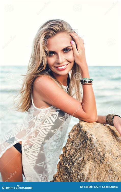 Attractive Blonde Girl With Long Hair Is Posing To The Camera On Sea