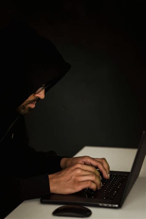 unrecognizable ethnic hacker typing  laptop  table  stock photo