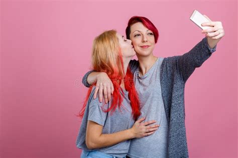 Embraces Of Two Young Lesbian Girls On A Pink Background Stock Image