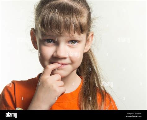Portrait Of A Shy Girl With Finger In Mouth On White Background Stock