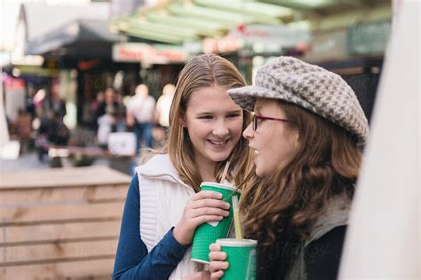 tween girls enjoing a smoothie and a chat whilst out shopping in the