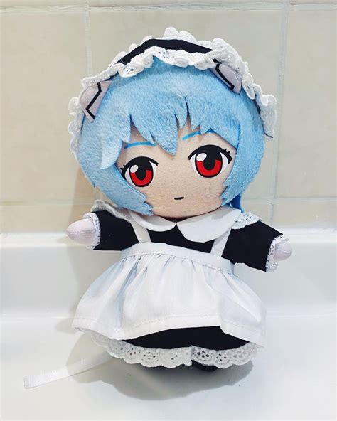 A Blue Haired Doll Sitting On Top Of A Bath Tub Next To A White Tiled Wall