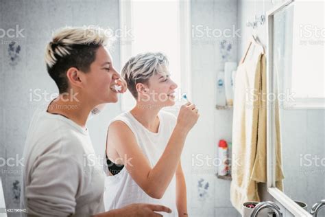 밀레니엄 세대 레즈비언 커플이 화장실에서 이빨을 닦고 얼굴을 씻는 것 20 24세에 대한 스톡 사진 및 기타 이미지 20