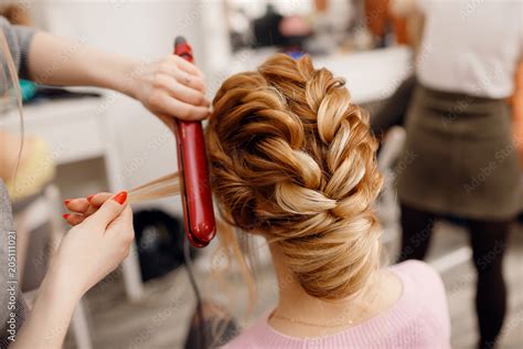 woman hairdresser making hairstyle  blonde girl  beauty salon