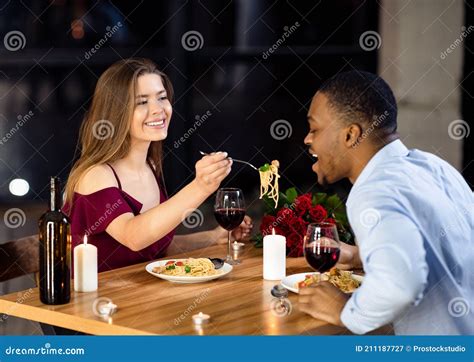 Cheerful Interracial Couple Having Fun At Dinner In Restaurant Woman